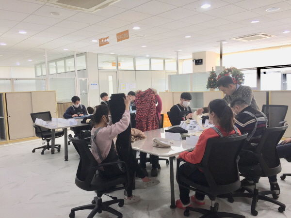 발달장애인들이 우리꿈터에서 직업기초기능훈련 중 하나인 스토어 상품 옷 개기 연습 중이다.