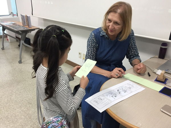 지난 1일 진행된 만화 워크숍에서 루치에 로모바가 참가 어린이의 작품을 살펴보고 있다.