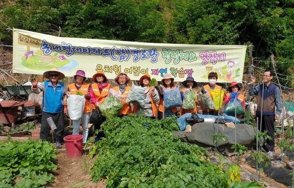 텃밭에서 농작물을 수확한 나눔터 리더들이 기념촬영을 하고 있다.