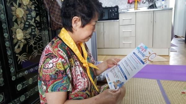 성남지역 홀몸 어르신이 폭염 때 행령 요령이 담긴 홍보물을 보고 있다