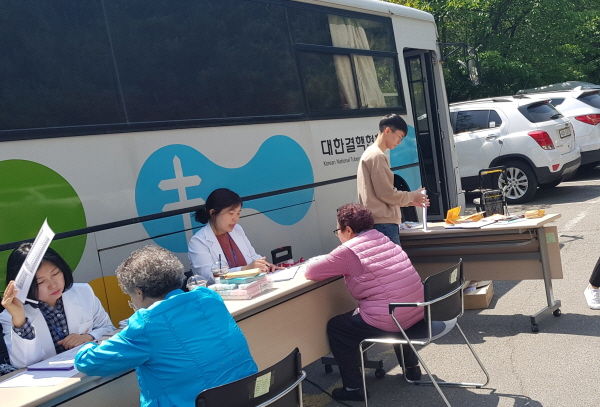 지역주민이 이동차량 앞에서 결핵 검진을 받고 있다.