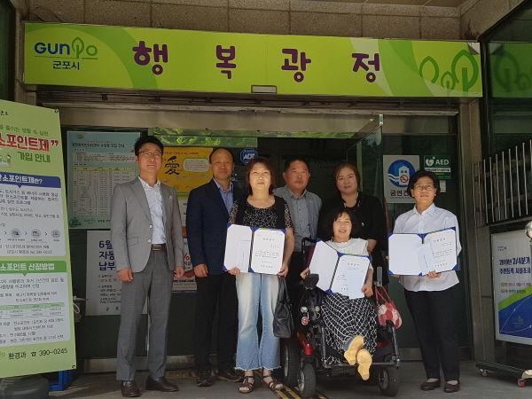 군포시 광정동이 군불재능장학회의 장학금을 지원 대상 학부모에게 전달하고 있다.