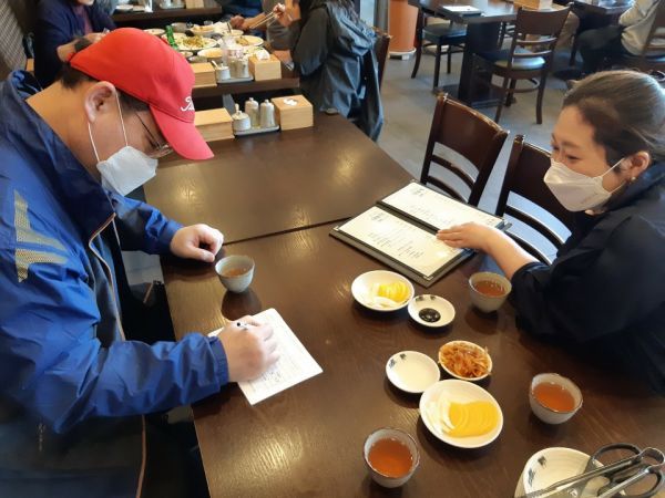 음식점 방문 시 건강질문서를 작성하는 이용자