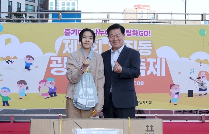 박승원 광명시장이 지난 1일 일직동 새빛공원로 차 없는 거리에서 열린 ‘제3회 일직동 광명새빛축제’에 참석해 상품을 전달하고 기념사진을 촬영하고 있다,