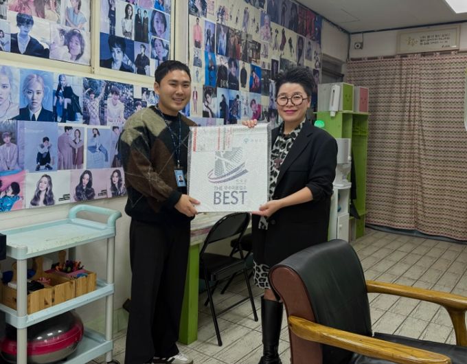 군 관계자가 공중위생서비스 평가 우수업소에 현판을 건네고 있다