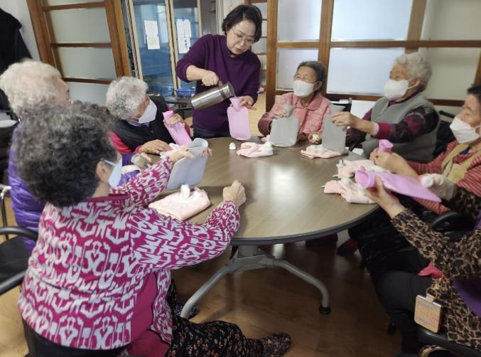 생활지원사가 온수 물주머니 사용법을 교육하고 있다