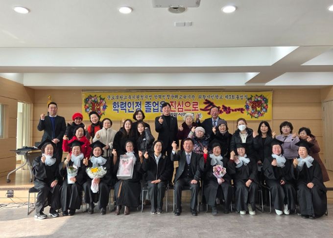 졸업생(의왕시민학교, 의왕시청)들이 학사모를 쓰고 환하게 웃으며 단체 기념사진을 촬영하고 있다.