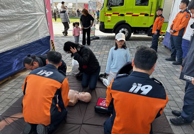 제54회 강진청자축제 119안전체험장에서 어린이와 부모님이 함께 심폐소생술을 배우고 있는 모습.